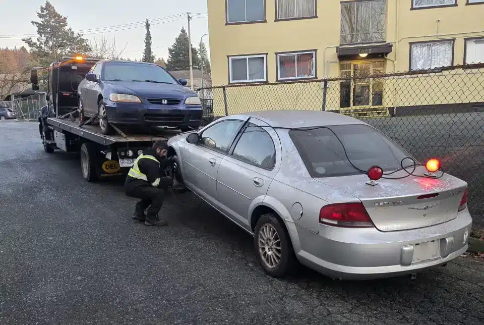 Two cars being hauled away for scrap